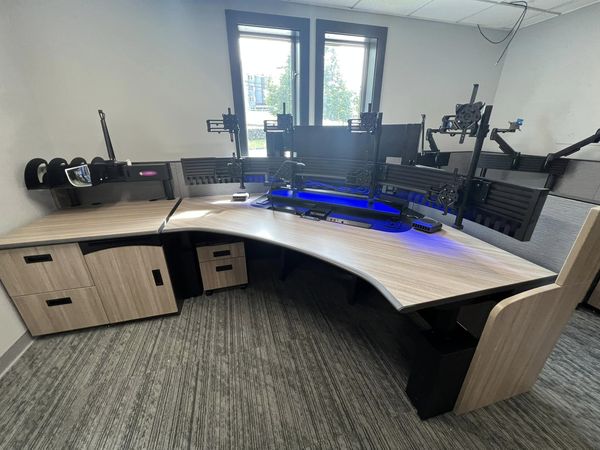 a computer desk with many monitor stands